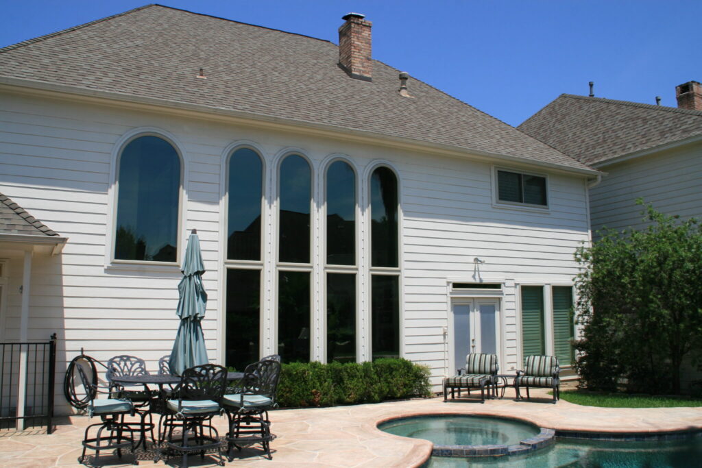 Champion Forest Exteriors installing energy-efficient windows on a home to reduce heat transfer and lower utility costs.